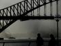 Słońce próbuje się przebić przez deszcz w okolicach słynnego Mostu Portowego w Sydney w Australii